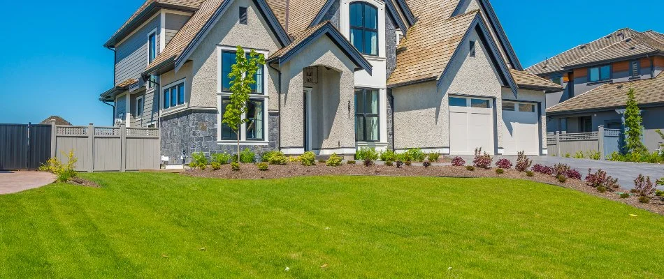 Large house in Huntesville, NC, with a green lawn and front landscaping.