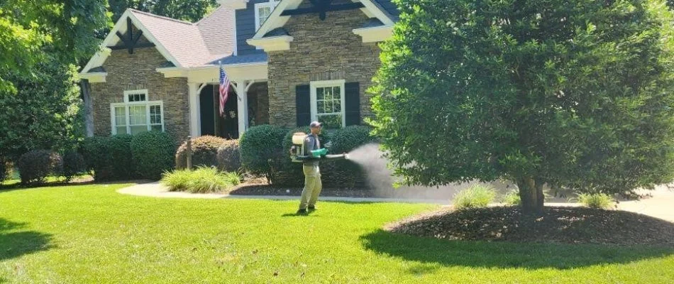 Worker using a fogger to treat a landscape in Fort Mill, SC.