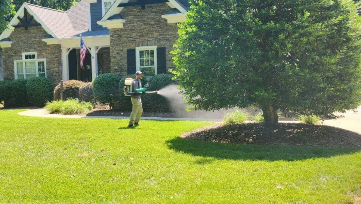 Employee using backpack fogger in Mooresville, NC for mosquito control.